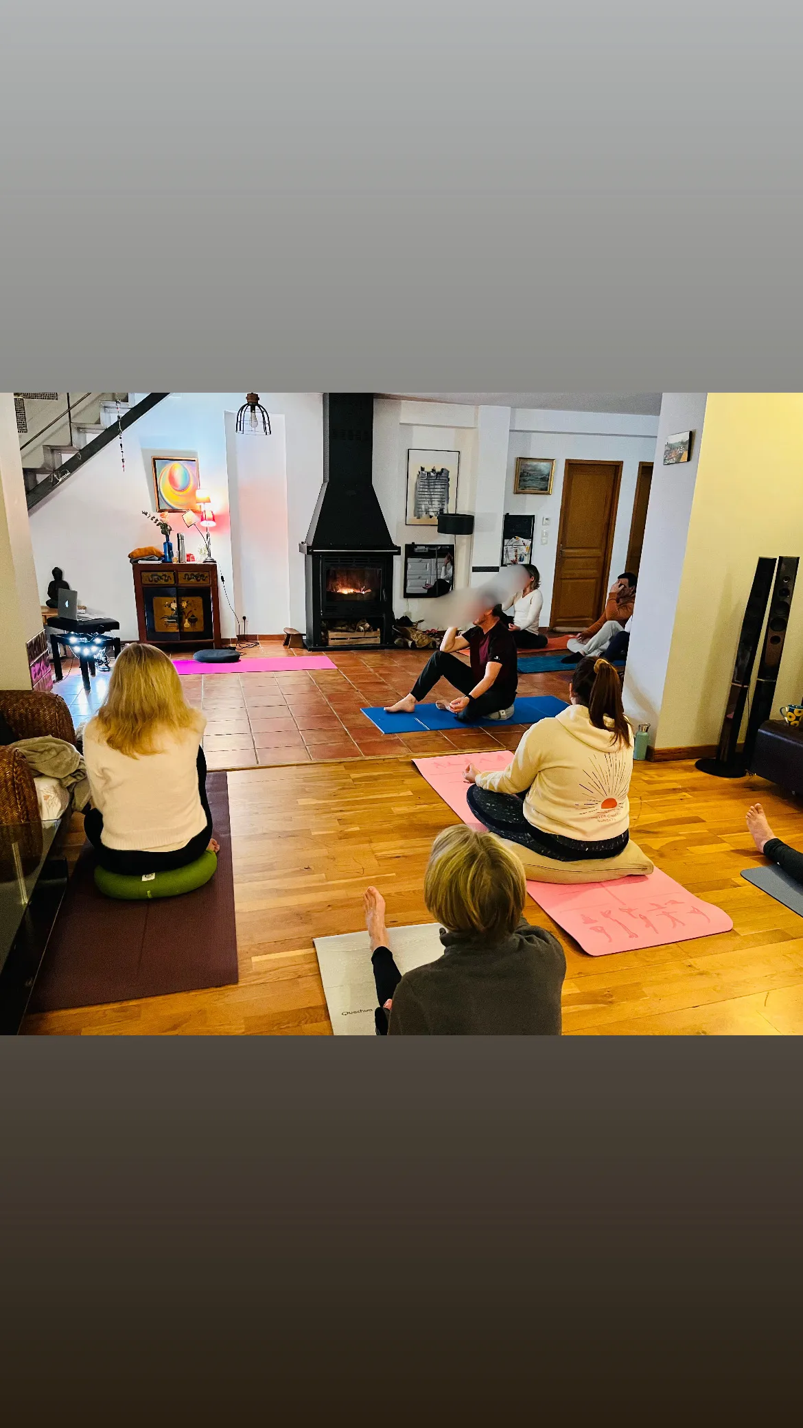 Groupe de participantes assises sur leurs tapis pendant un cours de yoga